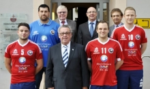 Die Handballer des TV Nieder-Olm werben auf ihren Trikots demnächst für das Rheinhessenjubiläum. Hinten von links: Trainer Markus Herberg, TV-Vorsitzender Reinhard Schmitt, Stadtbürgermeister Dieter Kuhl, Beigeordneter Franz-Josef Schatz. Vorne von links: Christopher Gaul, Peter Eugen Eckes (Vorsitzender Rheinhessen-Marketing), TV-Kapitän Tino Stumps und Lukas Berkessel.