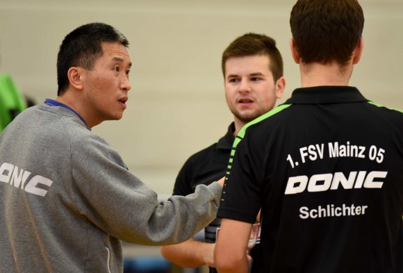 Li Bing (l.) wird sich am Wochenende voraussichtlich nicht darauf beschränken können, die Drittligaspieler des FSV Mainz 05 zu coachen. Weil Jonas Christmann (M.) erkrankt ist, muss der Trainer selbst an die Platte.