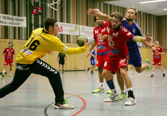 Florian Caprano (blaues Trikot) kommt nicht an den Ball, weil Benjamin Kröhle und Manuel Blezinger ihn abschirmen, SFB-Torwart Jannik Gippert greift sich das Spielgerät.