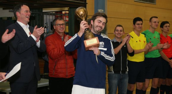 Im Stadtteil bleibt er, aber den Verein wechselt der Pott: Schott-Kapitän Marco Senftleben stemmt den Siegerpokal, den ihm Oberbürgermeister Michael Ebling (l.) übergeben hat, nach einem 12:0-Kantersieg im Finale gegen die TSG Hechtsheim in die Höhe.