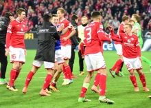 Gaetan Bussmann (blaue Jacke) muss sich nach dem Schlusspfiff der Glückwünsche von Stefen Bell und Yunus Malli (v.l.) erwehren.