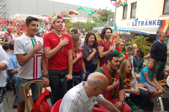 Mit der Hand auf dem Herzen folgen junge Portugiesen der Nationalhymne.