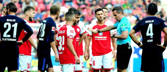 Nur die Ruhe: Schiedsrichter Tobias Stieler bittet die Elfmeter fordernden Mainzer um Geduld, bevor er sich die fragliche Szene anschaut ...