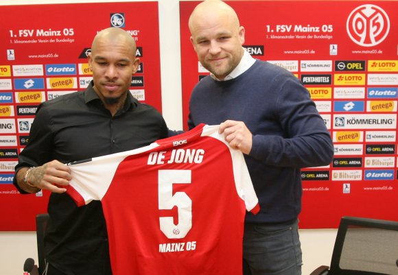 Die Nummer 6 bleibt bei Danny Latza, die Aufgaben des Sechsers bei den 05ern übernimmt aber ab sofort auch Nigel de Jong. Der 33-jährige Blitztransfer präsentierte gerade drei Stunden, bevor er erstmals mit der Rückennummer 5 auf dem Platz stand, sein Trikot zusammen mit Sportvorstand Rouven Schröder.