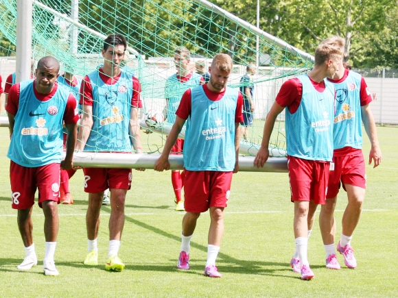 In allen Belangen sofort integriert ins Team: Daniel Brosinski (Mitte) hilft nach der Vormittags-Trainingseinheit dem Tor vom Platz.