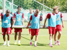 In allen Belangen sofort integriert ins Team: Daniel Brosinski (Mitte) hilft nach der Vormittags-Trainingseinheit dem Tor vom Platz.