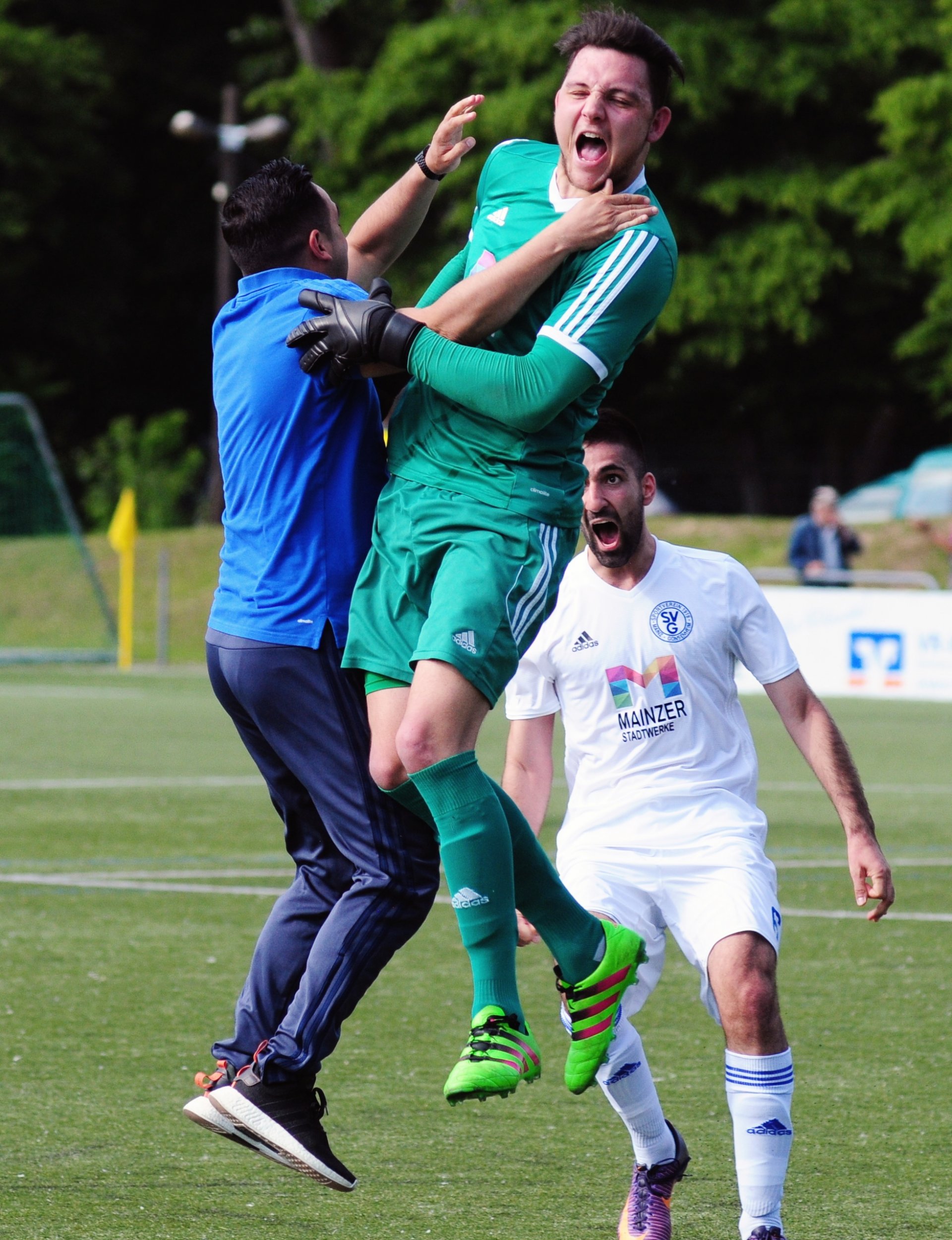 Im Stile eines Sprinters eilte Babak Keyhanfar nach dem 2:0 auf den Platz. Der erste Spieler, der dem Gonsenheimer Trainer begegnete, war Torhüter Paul Simon – an Sprungkraft etwas überlegen. Auch beeindruckend: Balcan Saris (r.) Jubelschrei zog sich über eine lange Sequenz, ohne dass der Innenverteidiger den Mund schließen oder Luft holen musste.