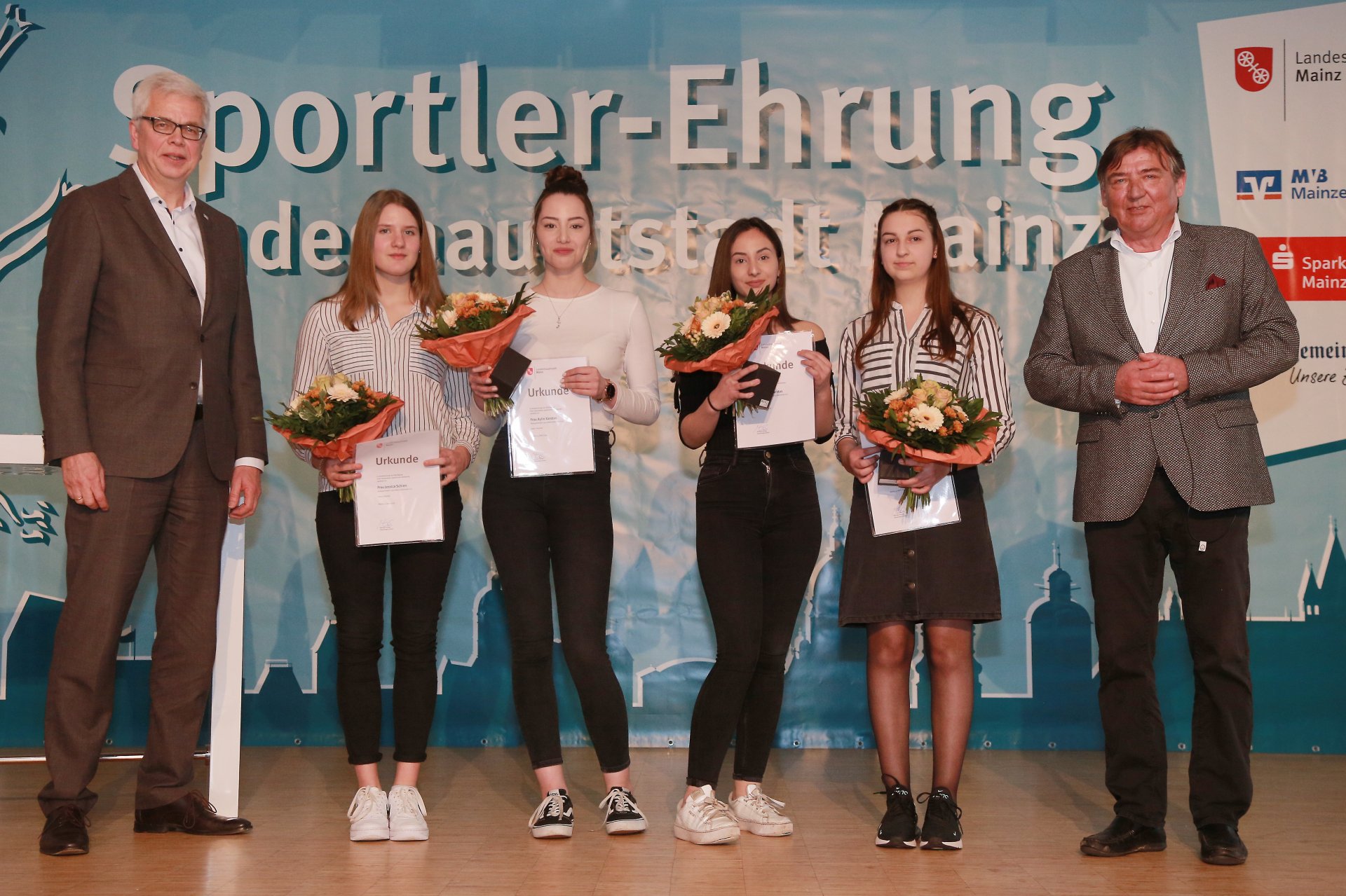 Ihren Titel aus dem Jahr 2017 erfolgreich verteidigt hatten Jessica Schien, Melissa Schwarz, Aylin Karatas und Yarem Karatas. Die Sportlerinnen des RV Ebersheim siegten im 4er Kunstradfahren bei den Deutschen Schülermeisterschaften. Flankiert werden sie von Herbert Kohlberg (l.), als Vorstandsmitglied der Mainzer Volksbank einer der Paten, und Sportdezernent Günter Beck.