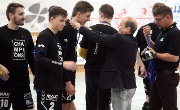 HVR-Präsident Klaus Kuhn musste sich bei dem eine oder anderen Sportler etwas recken, aber er konnte den Meisterspielern der Sportfreunde Budenheim II, hier Lucas Weil, die Meistermedaillen umhängen.