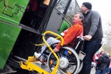 Mit einer eigens eingebauten Hebevorrichtung hievt Busunternehmer Johannes Fischer die Rollis (in diesem Fall: Jürgen Keil)  in den Bus.