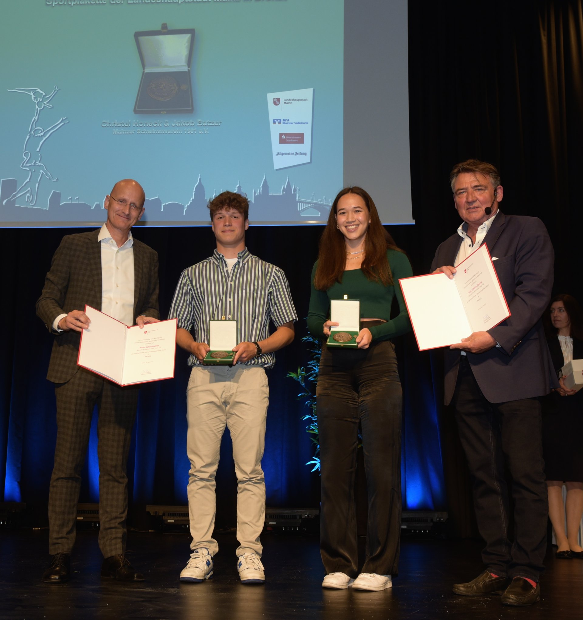 Gleich drei neue Gesichter auf der Sportlerehrungsbühne: Marcus Walden (l.), der Vorstandsvorsitzende der Rheinhessen Sparkasse, war erstmals als Pate dabei. Christel Honeck und Jakob Batzer vom MSV 01 wurden für ihre Erfolge im Turmspringen geehrt. Ihre Wege zu diesem Sport verliefen unterschiedlich. Honeck begeisterte sich in Taiwan, der Heimat ihrer Mutter, für den Sport. Batzer legte man es einst in der Vorbereitung auf das „Seepferdchen“ nahe, es doch mal aus der Höhe zu probieren. „Inzwischen kann ich aber auch schwimmen.“