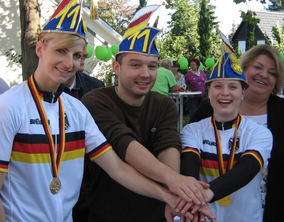 Zum elften Mal haben sich Katrin Schultheis (l.) und Sandra Sprinkmeier mit Trainer Marcus Klein für eine WM qualifiziert. Dafür gab's beim DM-Empfang des RV Ebersheim den passenden Kopfschmuck.