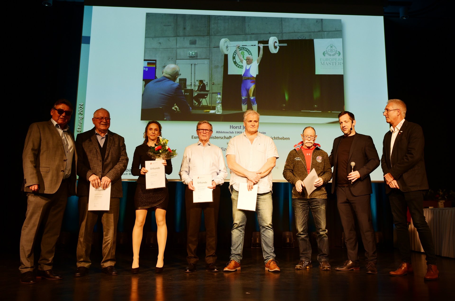 Horst Jooß und Peter Kirchenbauer vom AC Laubenheim flankieren Karin Ruß, Erich Metten und Oliver Kaiser (AC Weisenau). Die Gewichtheber heimsten etliche Medaillen bei Welt- und Europameisterschaften ein, Kirchenbauer gewann unter anderem EM-Gold der M75. Die von Kaiser trainierte Karin Ruß wurde Deutsche Meisterin der AK2. 