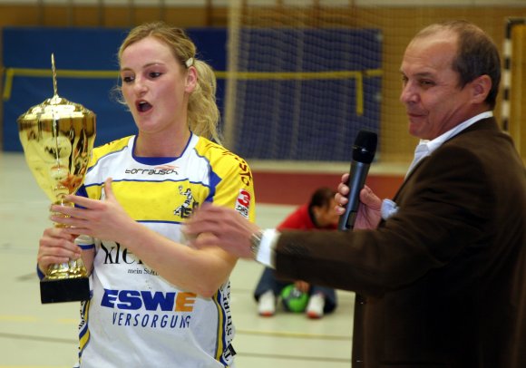 Blitzt golden, wird durch 600 Euro und den Startplatz im DHB-Pokal versilbert: Diana Hollerbach nimmt von HVR-Chef Klaus Kuhn die mühelos eroberte Siegertrophäe des Frauenwettbewerbs entgegen.