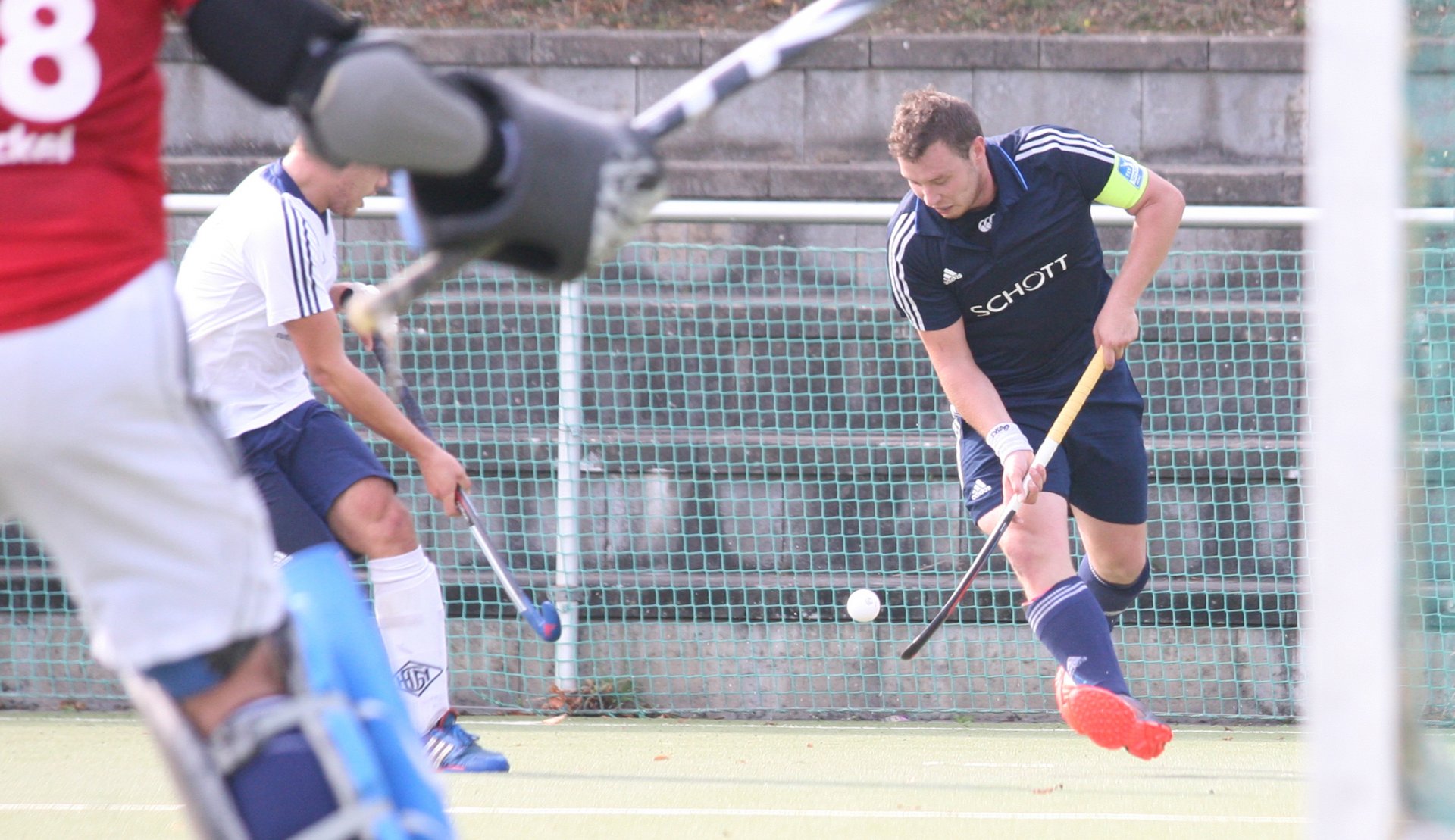 NOVEMBER – Die Hockeyabteilung des TSV Schott strukturiert im Herbst einmal mehr um. Der hauptamtliche Trainer der Regionalliga-Männermannschaft, Kai Stieglitz, darf zwei Jahre, nachdem er für diese Aufgabe geholt worden war, in den Jugendbereich wechseln. Die Nachfolgefrage wird intern gelöst: Kapitän Alexander Hemmersbach fungiert seit der Hallenrunde als Spielertrainer. Dabei hat er keinen ganz leichten Zeitpunkt erwischt um den Einstieg ins Trainerfach im Aktivenbereich anzugehen, denn schon den ersten Teil der Feldrunde 14/15, noch unter Stieglitz, schloss die Mannschaft auf einem Abstiegsplatz ab. Nicht besser sieht es zum Jahreswechsel nach der Halbzeit der Hallenrunde aus. Doch Hemmersbach ist durchaus optimistisch, den Klassenverbleib in beiden Saisons noch zu schaffen.