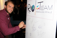  Julian Weber setzt seine Unterschrift auf die Teilnehmerliste des Teams Rio.
