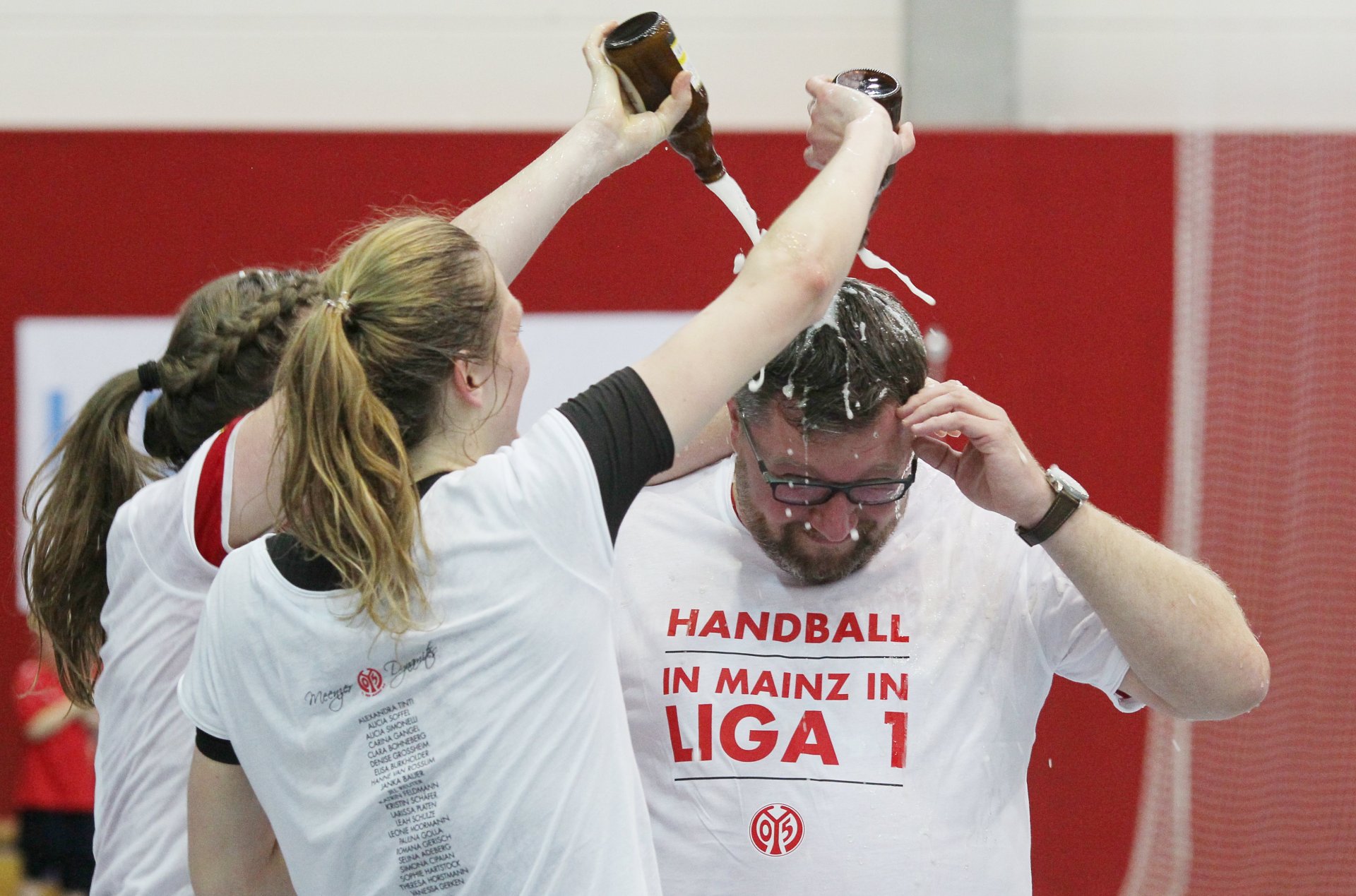 Alicia Soffel und Sophie Hartstock schenken ihrem Trainer Thomas Zeitz eine Extraladung Bier.